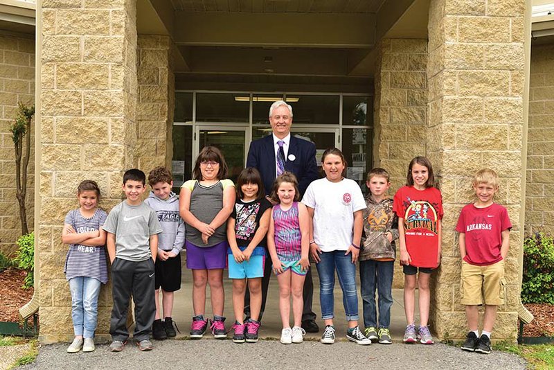 Mayflower School District Superintendent John Gray stands with some of the students affected by the April 27, 2014, tornado that killed four people in the community and destroyed homes and businesses. Gray said enrollment in the district is still down since the storm, and a few teaching positions vacated “by natural attrition” will not be filled.