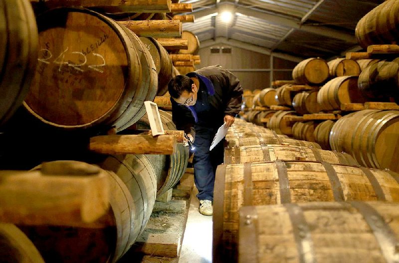 An employee checks casks of Ichiro’s Malt brand whiskies at Venture Whisky Ltd’s Chichibu distillery in Chichibu, Japan, in March. 