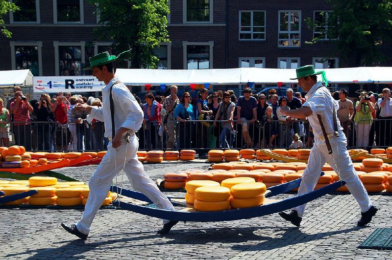 At the Friday market in Alkmaar, Netherlands, carriers use a “cheese-barrow” to bring wheels to and from the Weigh House, just as they have for centuries. 
