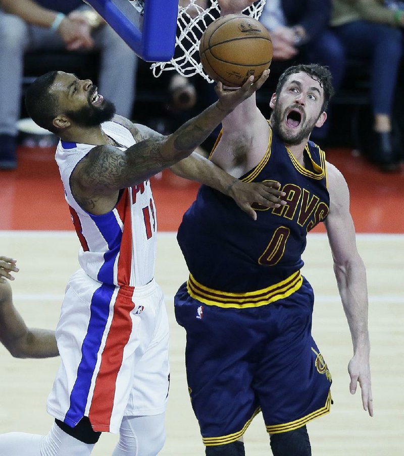 Cleveland defender Kevin Love (right) tries to block a shot by Detroit forward Marcus Morris during Friday’s NBA playoff game. The Cavaliers held on for a 101-91 victory to take a 3-0 lead in their Eastern Conference first-round series.