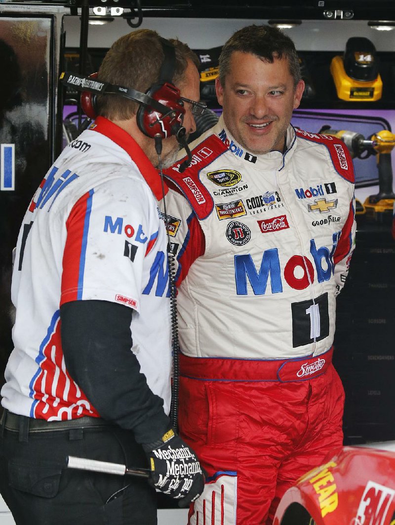 Tony Stewart, right, jokes with a crew member during practice for Sunday's NASCAR Sprint Cup auto race at Richmond International Raceway in Richmond, Va., Friday, April 22, 2016. 