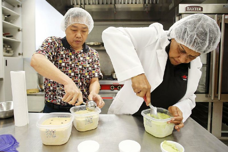 Navam Hettiarachchy (right), a University of Arkansas food scientist, and research associate Ronny Horax scoop out servings of a soybean-based spinach vanilla frozen dessert.