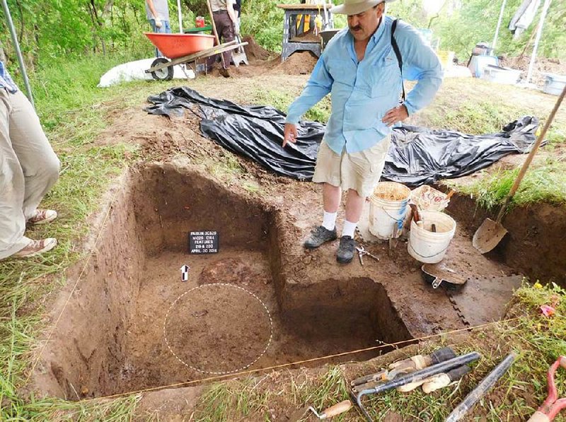 Site archaeologist Jeffery Mitchem of the Arkansas Archeological Survey points to the pattern of a posthole
at the spot in Parkin Archeological State Park where a team found a large wooden post in 1966.