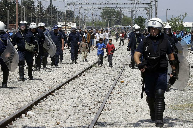 Greek police patrol Friday at a train station that has become a makeshift camp for about 54,000 migrants stranded at the northern Greek border crossing of Idomeni.