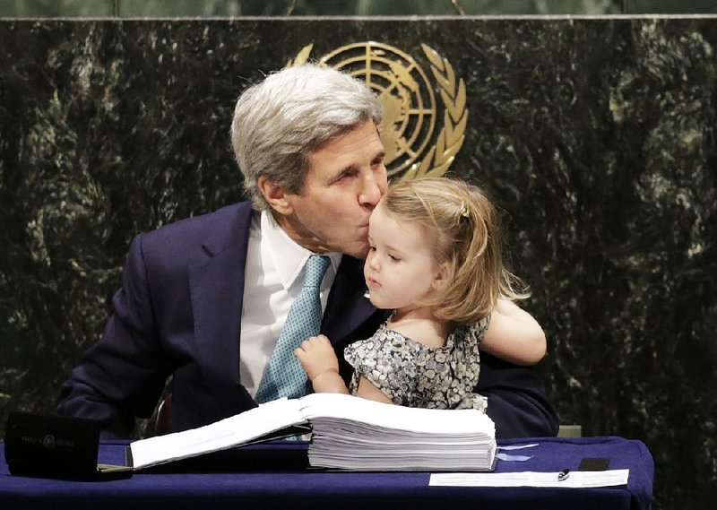 Secretary of State John Kerry gives granddaughter Isabel Dobbs-Higginson a kiss after signing the Paris Agreement on climate change Friday at the United Nations headquarters.