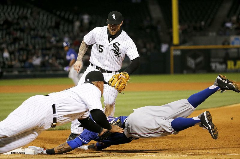 Chicago White Sox first baseman Jose Abreu (front left) tags out Ian Desmond of the Texas Rangers for the second out of a triple play during the seventh inning of the White Sox 5-0 victory over Texas on Friday night. The play started when right fielder Adam Eaton caught a fly ball from Mitch Moreland. Eaton threw to Abreu, who tagged out Desmond. Abreu threw to catcher Dioner Navarro, who threw to shortstop Tyler Saladino, who threw to third baseman Todd Frazier, who tagged Prince Fielder out. 