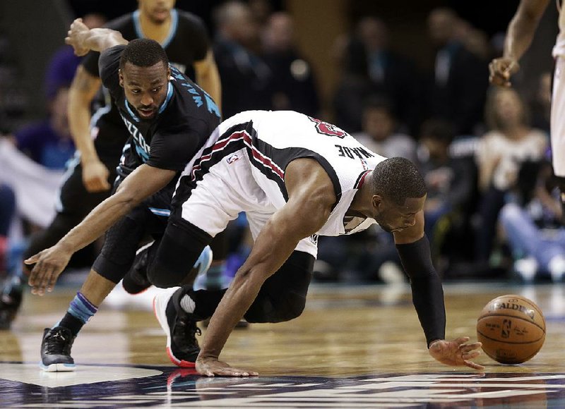 Miami’s Dwyane Wade (right) and Charlotte’s Kemba Walker go after a loose ball during Saturday’s NBA playoff game. The Hornets cut their series deficit to 2-1 with a 96-80 victory behind Walker’s 17 points.