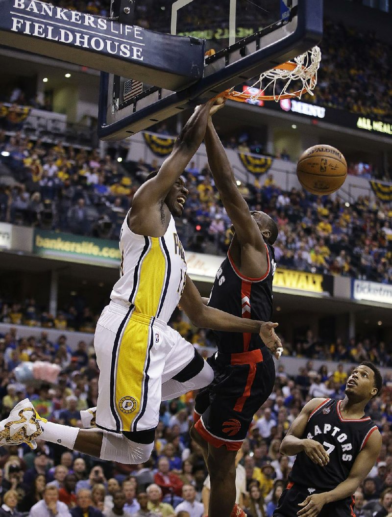 Indiana forward Ian Mahinmi (left) dunks over Toronto center Bismack Biyombo during Game 4 of their NBA Eastern Conference playoff series Saturday. Mahinmi finished with 22 points, 10 rebounds and 5 assists as the Pacers beat the Raptors 100-83. 
