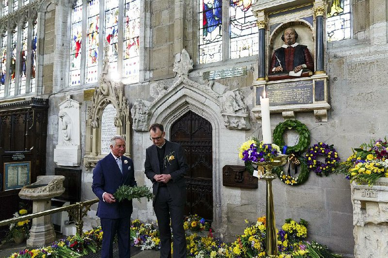Britain’s Prince Charles (left) lays a wreath on the grave of William Shakespeare during a visit Saturday to Holy Trinity church in Stratford-upon-Avon, England.