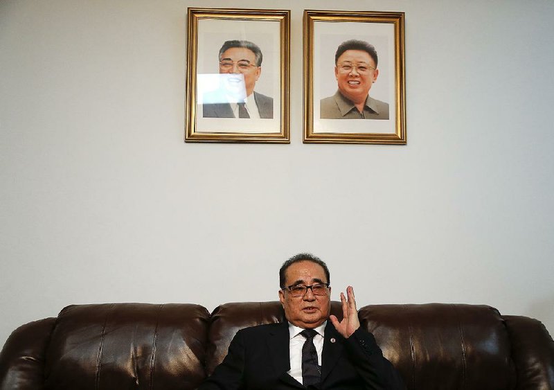 Seated under portraits of former North Korean leaders Kim Il Sung (left) and Kim Jong Il, North Korean Foreign Minister Ri Su Yong answers questions Saturday at his country’s United Nations post in New York.