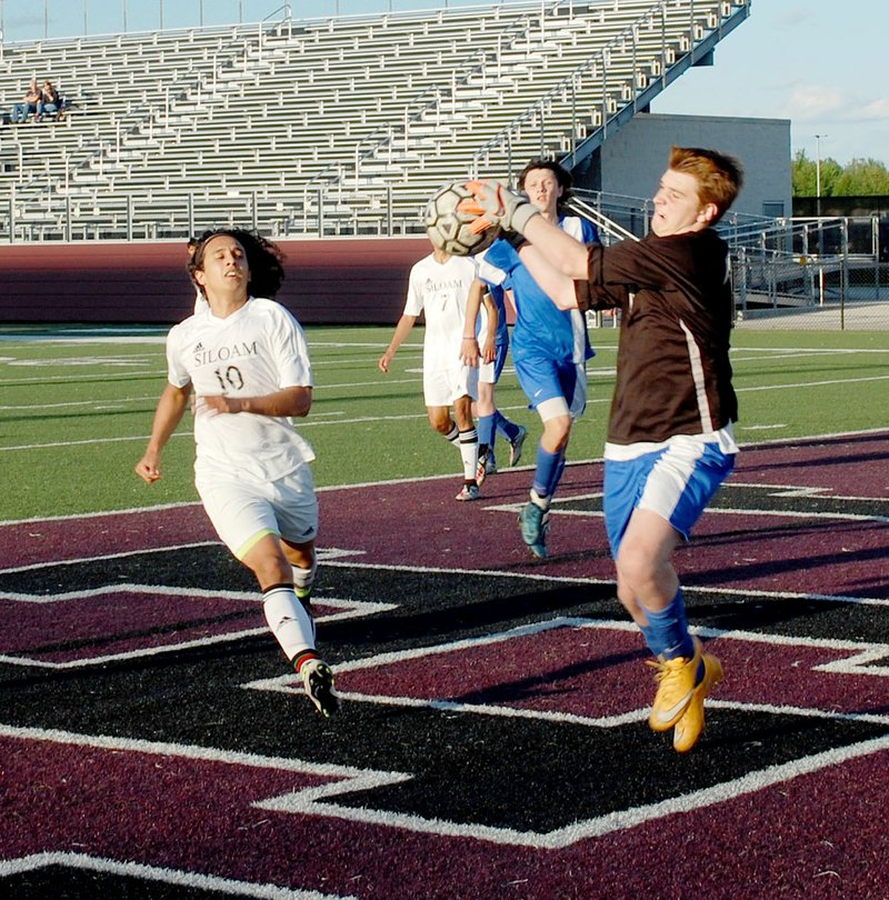 Graham Thomas/Siloam Sunday Siloam Springs senior forward Aldair Umana runs in on a play as Harrison&#8217;s goalkeeper Daniel Bettis makes the save on Thursday. The Panthers defeated the Goblins 8-1 in a nonconference match at Panther Stadium.