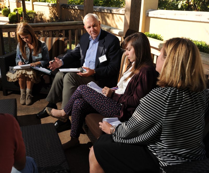 Paul Hewitt (center), superintendent of Fayetteville Public Schools, speaks Tuesday, Oct. 13, 2015, with Teresa Fuller, a parent (from left); Sarah Brady, a graduate of the school district; and Karyn Francis, a teacher at Vandergriff Elementary School; at the Courtyard Mariott in Fayetteville. 