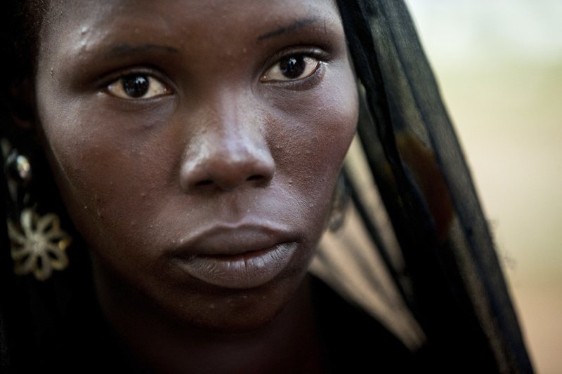 A girl identified as Monica, listens to a translator explain how she managed to escape Boko Haram during a Bring Back Our Girls vigil in Abuja, Nigeria, Thursday, April 21, 2016, which, two years after Boko Haram abducted the girls from their school, is still held daily.  