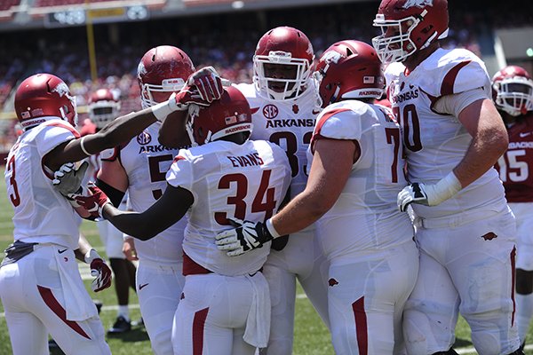 Arkansas running back Denzell Evans (34) celebrates with teammates in the end zone Saturday, April 23, 2016, after carrying the ball for a touchdown during the annual spring Red-White game in Razorback Stadium.