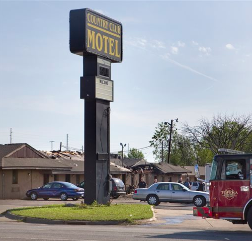 Authorities continue working the scene Sunday, April 24, 2016, at the Country Club Motel in Topeka, Kan., where two deputy U.S. marshals and one FBI agent suffered gunshot wounds as they tried to arrest a robbery suspect late Saturday night.