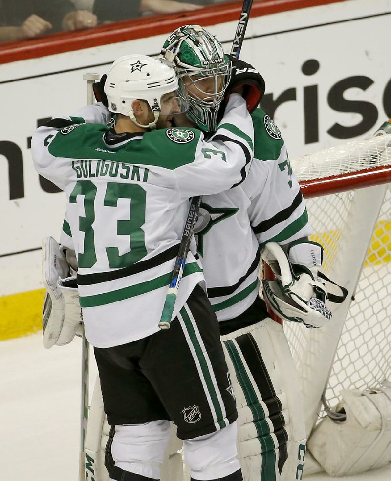 Defenseman Alex Goligoski (left) hugs goalie Kari Lehtonen after they led Dallas past Minnesota 5-4 in Game 6 of their NHL playoff series Sunday.