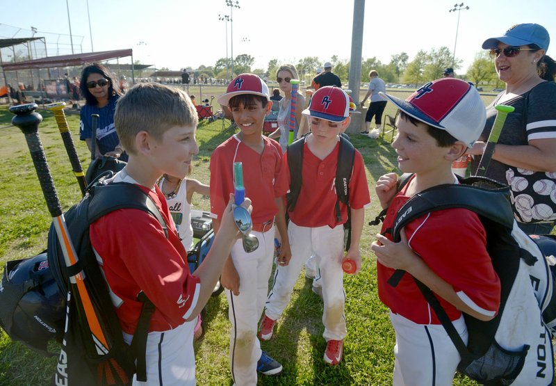 Will Anderson (from left), Spencer Mounce, Parker Morris, and Bren Palmer of the PT Morris 10U team from Perfect Timing in Springdale chat Saturday after winning their pool round game on the second day of the Golden Glove Showcase youth baseball tournament at Memorial Park in Bentonville.