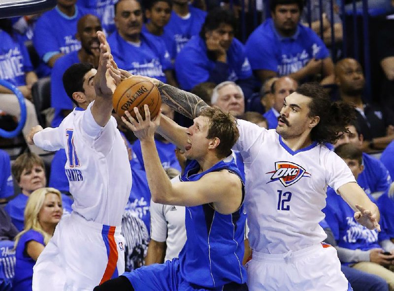 Dallas forward Dirk Nowitzki (center) splits Oklahoma City defenders Enes Kanter (left) and Steven Adams during the first half of Monday night’s NBA playoff game. Nowitzki finished with 24 points, but it wasn’t enough as the Thunder beat the Mavericks 118-104 to win their first-round series 4-1.