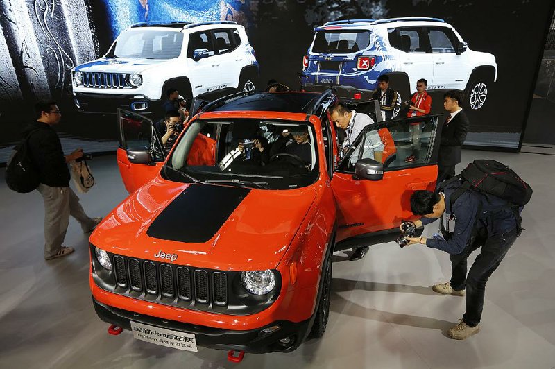 Journalists look at the new Jeep Renegade after it was unveiled Monday at the Beijing Automotive Exhibition in Beijing.