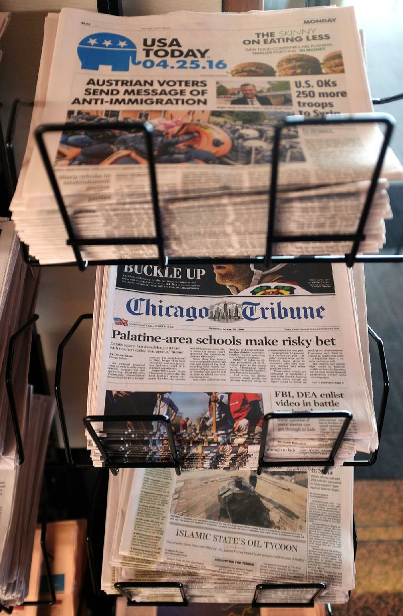 USA Today, Chicago Tribune and other newspapers fill a sales rack at Chicago’s O’Hare International Airport on Monday in Chicago. USA Today publisher Gannett said Monday that it has made an offer to buy Tribune Publishing.