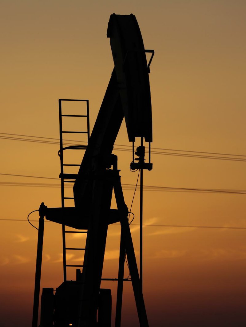 A pump jack works at sunset in the desert oil fi elds of Sakhir, Bahrain, on April 16.