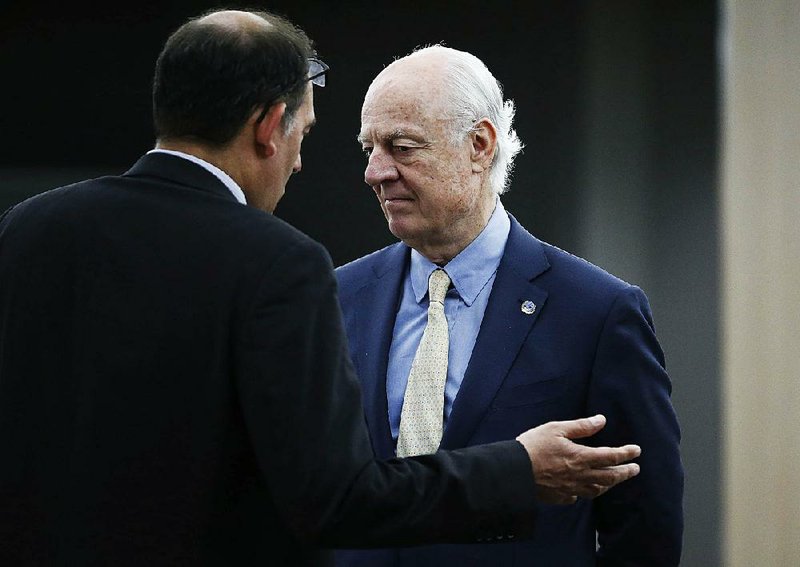 U.N. mediator Staffan de Mistura (right) listens to a member of his staff before a meeting with the Syrian government delegation during Syria Peace talks Tuesday at the United Nations in Geneva.