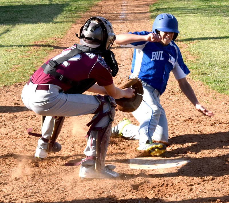 Photo by Mike Eckels In a controversial call at home plate, Decatur&#8217;s David Lopez slides across home plate just as the Hartford catcher tags him during the last regular season game against the Hustlers on April 21. Lopez was called out in the play.