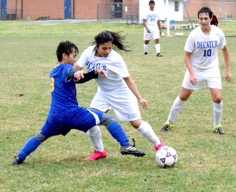 Photo by Mike Eckels With David Lopez (Decatur #10) as back up, Reyna Marciel (#1) fights to keep the ball away from a Panther player during the Decatur-Bergman soccer match at Bulldog Stadium in Decatur April 19. The Bulldogs pulled off their first win of the season, 8 to 0.