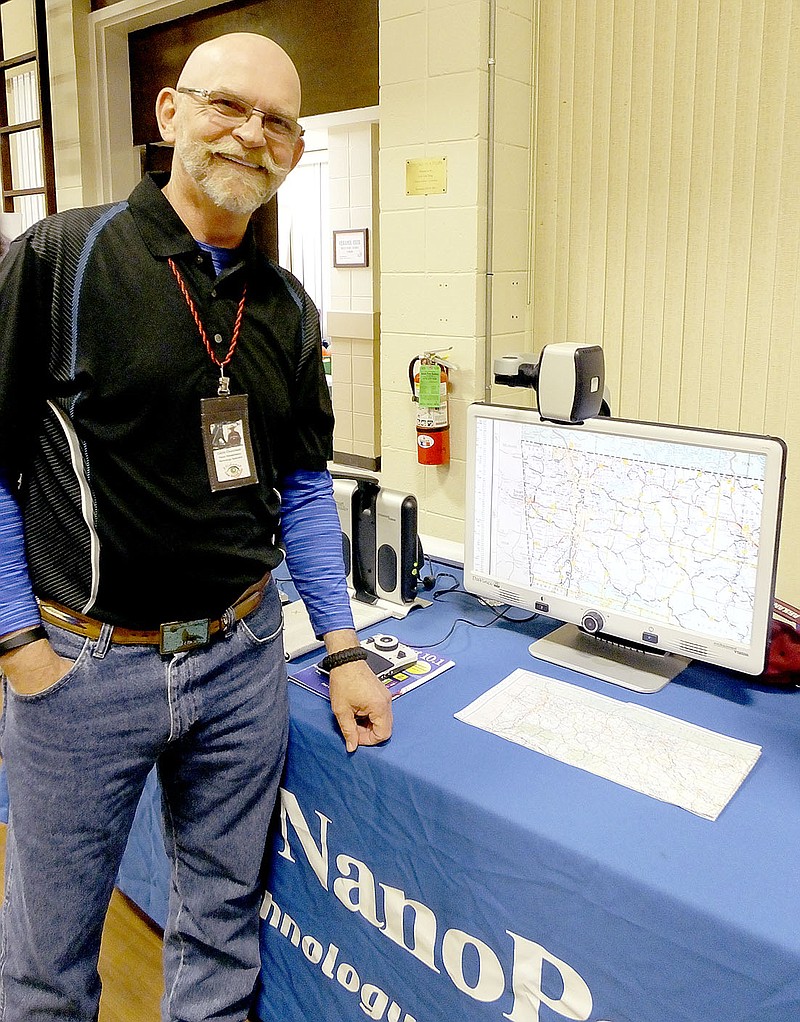 Lynn Atkins/The Weekly Vista Calvin Churchwell, a vendor at the Senior Services Expo in Riordan Hall last Thursday, demonstrates a device that enlarges printed materials for people with visual impairments. He can enlarge maps, documents, newsprint or magazines, he explained. The company is NanoPac and the device is available in a pocket sized model as well as a desktop model with a large screen.