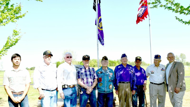 Photo by Mike Eckels Six recipients of the Military Order of the Purple Heart stand with city and county officials during an April 23 ceremony at Veterans Park in Decatur. They are Richard Boyd (left), Henry Walker, Bob Clinard, Chuck Adkins, Guy Pouvesle, E.S. Lawbaugh, Wayne Dirck, Jim Oden and Bob Tharp. The ceremony formally designated Decatur a Purple Heart City.