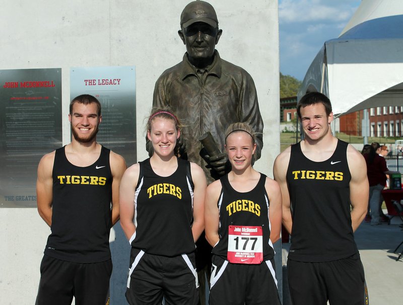 Photo courtesy of Tracy Walker From left, Prairie Grove&#8217;s Sydney Walker, Ashley Cox, Bekah Bostian and Coty Hoskins pose in front of legendary Arkansas Razorbacks track coach John McDonnell&#8217;s statue. All four participated in the John McDonnell Invitational on the University of Arkansas campus on April 23.