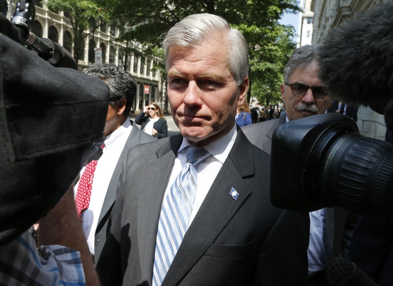 Former Virginia Gov. Bob McDonnell navigates a camera cluster as he leaves the 4th U.S. Circuit Court of Appeals in Richmond, Va., on May 12, 2015. The Supreme Court will decide how far politicians can go in doing favors for people who give them money as it takes up McDonnell’s case. 
