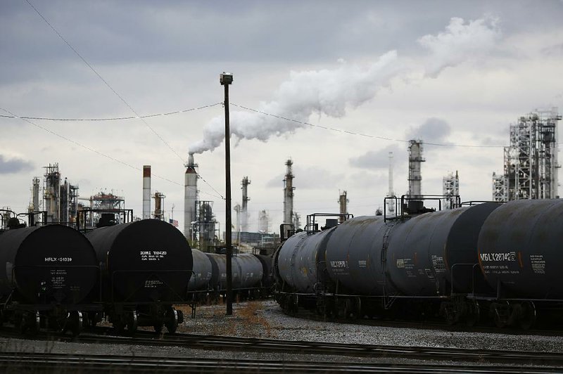 Railcars are parked outside the Paulsboro Refining Co. oil refinery in Paulsboro, N.J., earlier this month. Some oil industry analysts say their estimates for quarterly earnings for the big oil companies may be too low. 