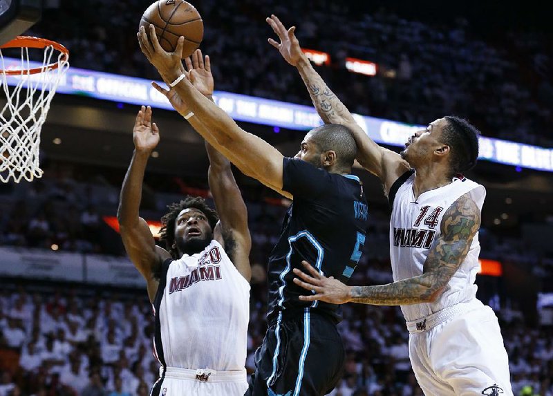 Charlotte guard Nicolas Batum (middle) goes up for a shot against Miami forward Justise Winslow (20) and guard Gerald Green during the Hornets’ 90-88 victory over the Heat on Wednesday in Miami. The Hornets lead the series 3-2 and can close it out with a victory in Charlotte on Friday.