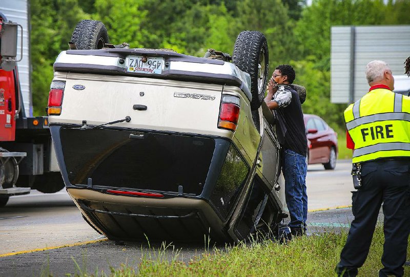 4/27/16
Arkansas Democrat-Gazette/STEPHEN B. THORNTON
Demetrius Mays pauses at the side of his overturned SUV as he awaits a wrecker along I-40 eastbound, west of the Springhill Dr. exit Wednesday morning in North Little Rock. Mays says a white car came into his lane and he moved to avoid it and overcorrected. Mays and his two passengers, who were wearing their seat belts, only suffered cuts and abrasions.