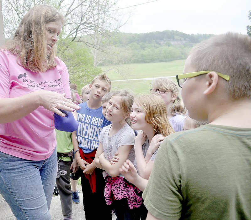 RACHEL DICKERSON/MCDONALD COUNTY PRESS Kirsten Alvey-Mudd of Missouri Bat Census shows third-graders from Grove, Okla., a bat during a presentation at Bluff Dwellers Cave in Noel on Tuesday.