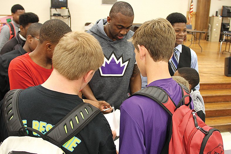 News-Times/Faith Lightsy Junction City graduate, and current Sacramento King, James Anderson signs autographs Wednesday afternoon at Barton Junior High School after speaking to the Gentlemen's Club.