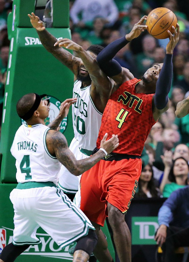 Atlanta’s Paul Millsap (4) grabs a defensive rebound over Boston’s Isaiah Thomas (4) during the Hawks’ 104-92 victory over the Celtics on Thursday in Boston. Millsap finished with 17 points and eight rebounds.  