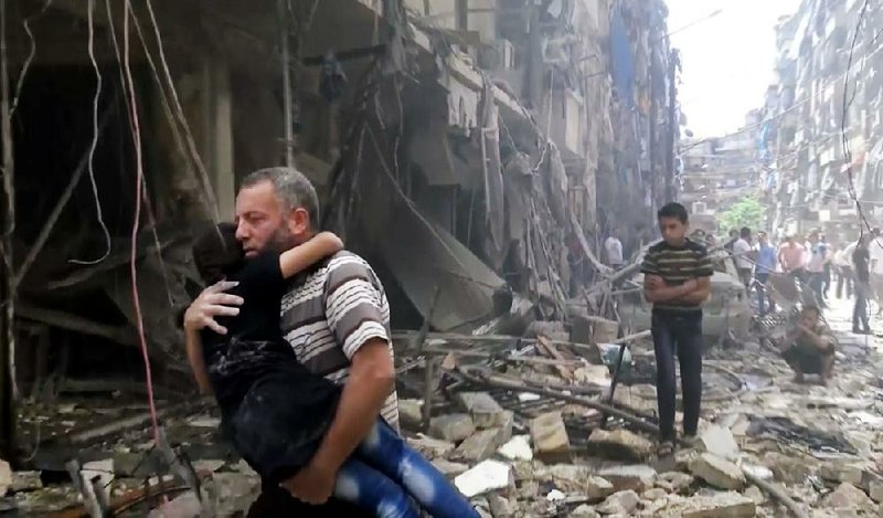 In an image taken from video, a rescuer hurries away with a child Thursday after airstrikes devastated parts of Aleppo, Syria.