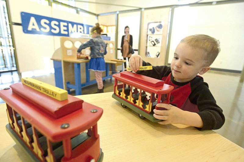 Waylon Jordan, 3, of Rogers assembles a neighborhood trolley during a members-only preview event for the new “How People Make Things” exhibit at the Scott Family Amazeum. The exhibit was inspired by the factory tour segments on the “Mister Rogers’ Neighborhood” television series.