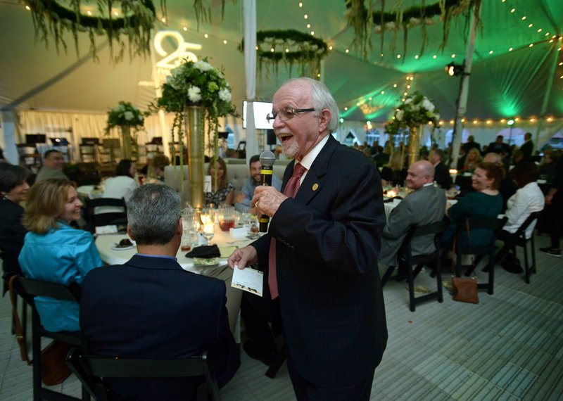 Dick Trammel walks from table to table encouraging donations Thursday during the Northwest Arkansas Community College Foundation’s annual Plant a Seed Soiree at NWACC in Bentonville.