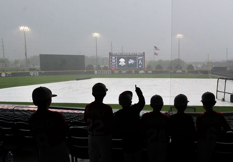 Fans watch during a rain delay Friday, April 29, 2016, at Baum Stadium in Fayetteville.