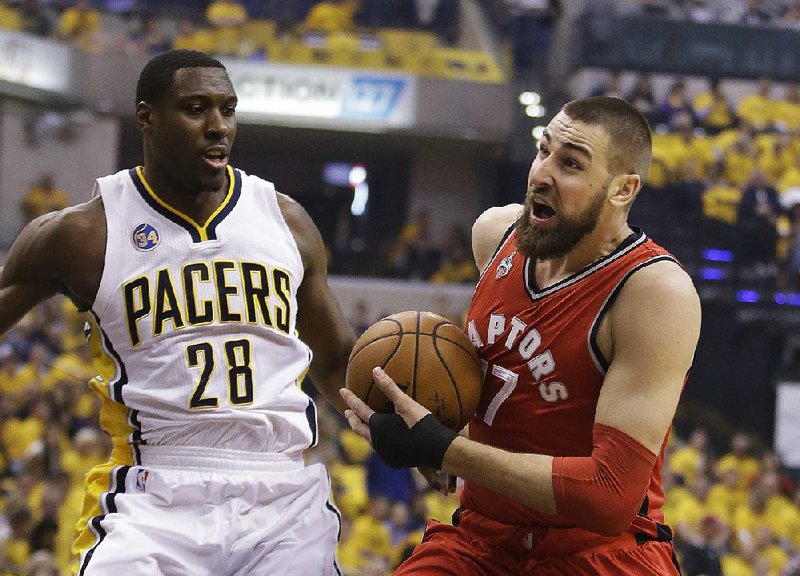 Toronto center Jonas Valanciunas (right) looks for room around Indiana forward Ian Mahinmi during the first half of Friday’s NBA playoff game. The Pacers pulled away for a 101-83 victory to force a Game 7 in their first-round series.