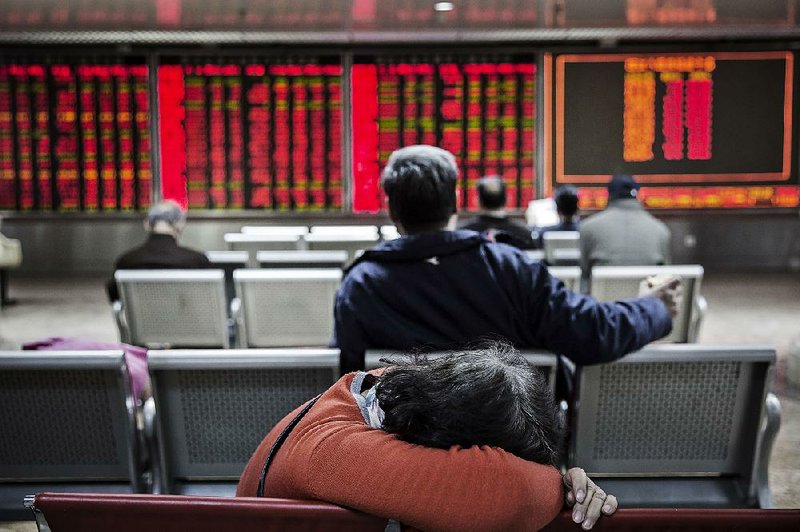 A woman rests at a securities brokerage in Beijing in this fi le photo. The general manager of China’s biggest stock brokerage and a prominent investor have been arrested on insider trading charges, the government said Friday.