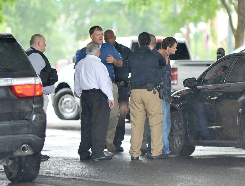 Police officers take a suspect into custody in Hot Springs after a bank robbery Friday at Simmons First Bank on Grand Avenue.