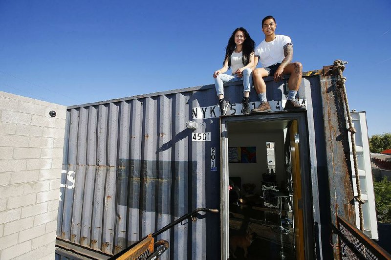 Patrick Tupas and his wife, Maria Real-Tupas, sit on the roof of their shipping container apartment in Phoenix. In the Containers on Grand project, the apartments are designed in a way that retains the corrugated metal exteriors.