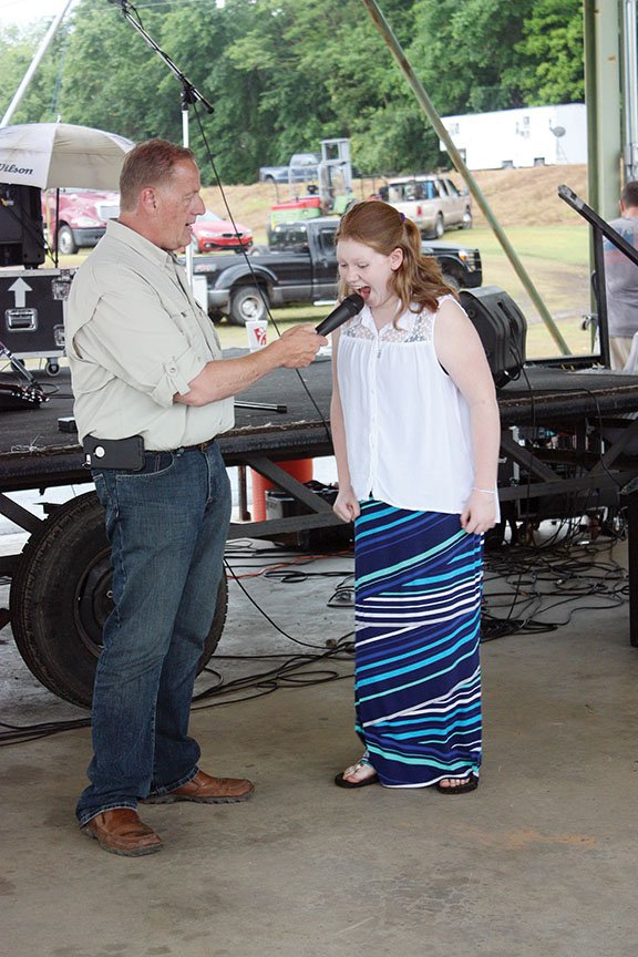Johnny Story, the master of ceremonies for last year’s Yell Fest yelling contest, gives Rene Dickerson, 12, of Conway her turn at the microphone. Dickerson won the age 12-and-under division. The 27th annual festival is scheduled for Friday and Saturday at Veterans Riverfront Park in Dardanelle