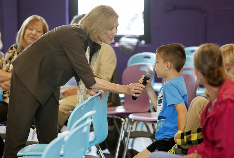 Julianna Roosevelt, great-granddaughter of former President Franklin D. Roosevelt, shares a microphone Friday with Hunter Stewart, a Washington Elementary School second-grader, as he asks a question at the Agee Lierly Life Preparation Center in Fayetteville. Roosevelt will be the speaker tonight at the fourth Celebrating Diversity Banquet at the Fayetteville Country Club.