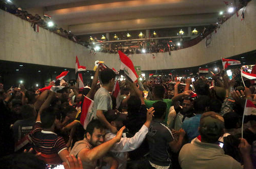 Supporters of Shiite cleric Muqtada al-Sadr storm parliament in Baghdad's Green Zone on Saturday, April 30, 2016. Dozens of protesters climbed over the blast walls and could be seen storming Parliament while carrying Iraqi flags and chanting against the government.