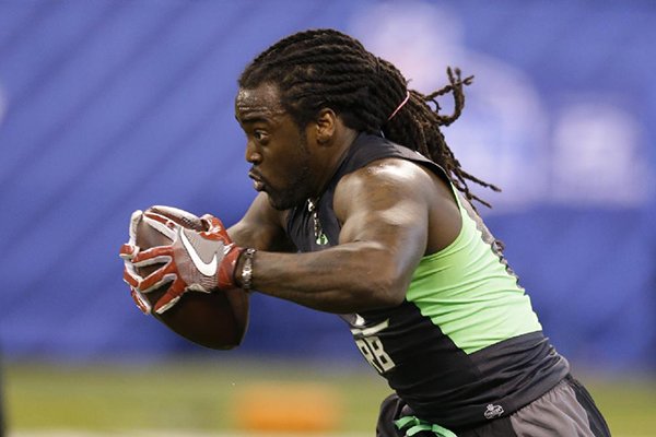 Arkansas running back Alex Collins runs a drill at the NFL football scouting combine in Indianapolis, Friday, Feb. 26, 2016. (AP Photo/Michael Conroy)